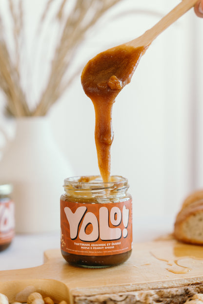 pot de Tartinade arachide et érable avec une cuillère au dessus du pot ouvert récoltant le contenu du pot