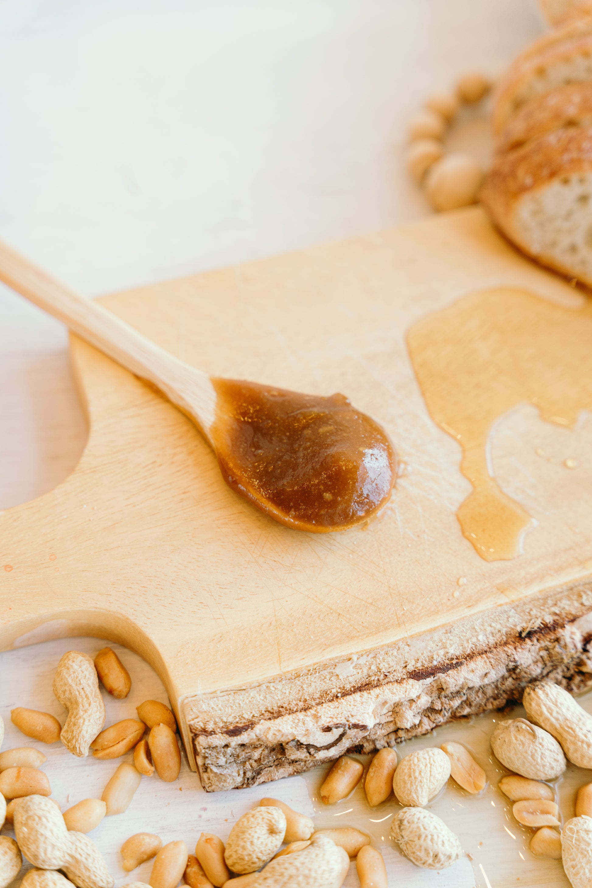 Une cuillèrede bois ur une planche à découpé qui contient la Tartinade arachide érable de yolonuts