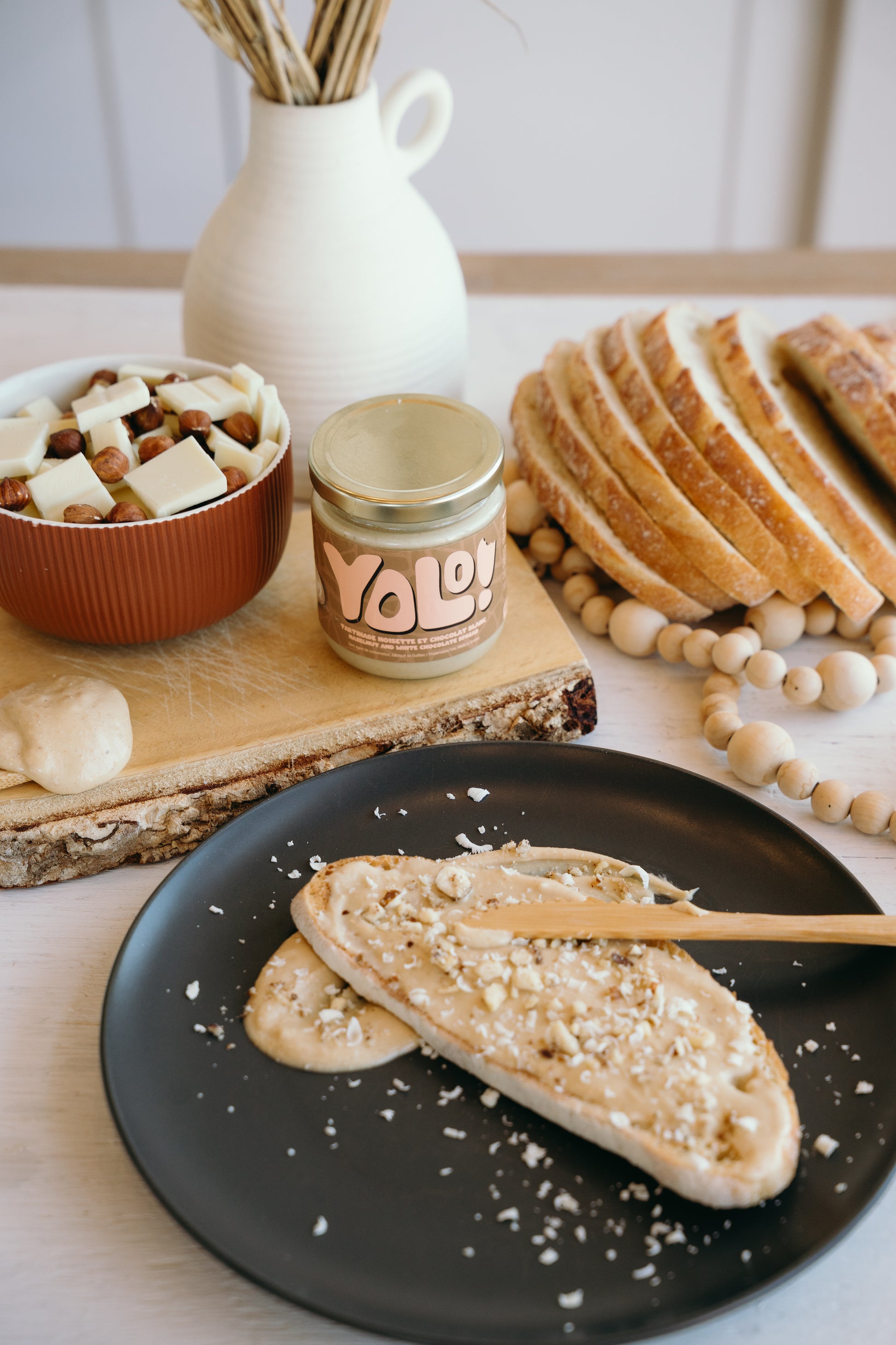 Tartinade de noisette et chocolat blanc sur des roties dans une assiette avec du croquant de noisette par dessus